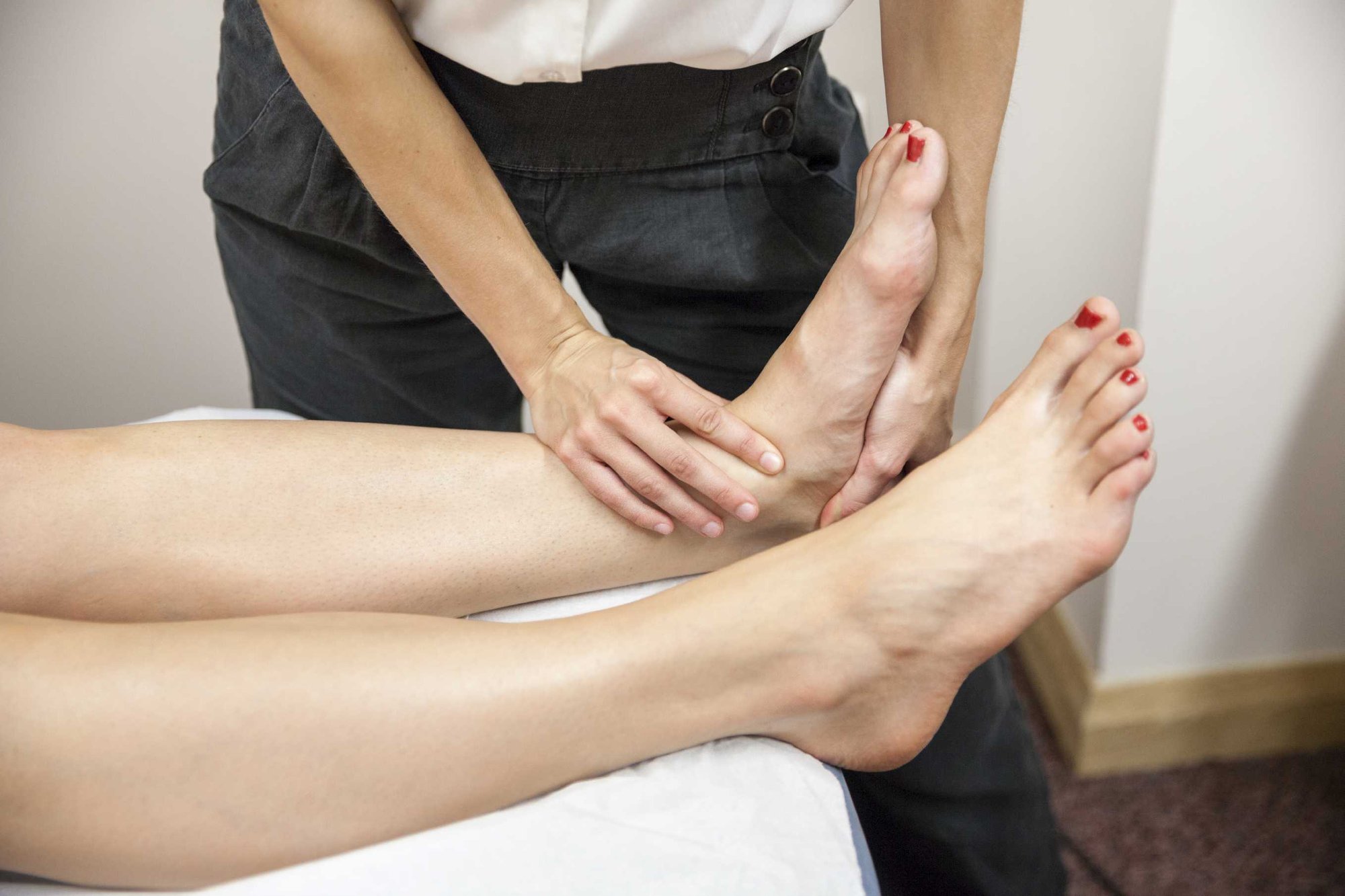 Chartered physiotherapist assessing a patient in clinic